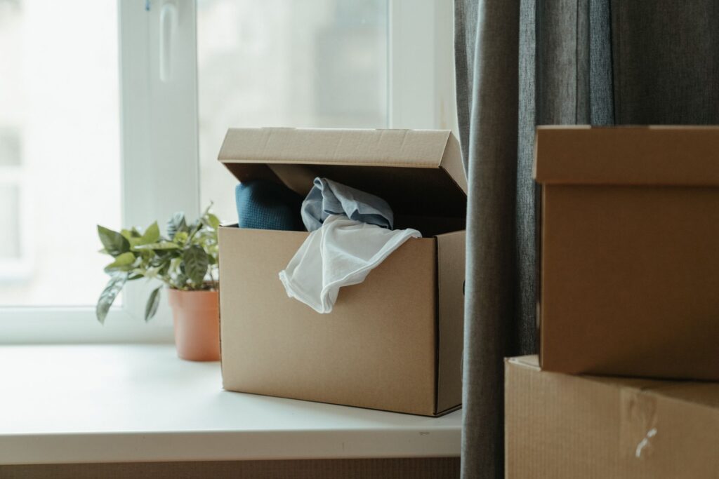 Packed cardboard boxes beside a window
