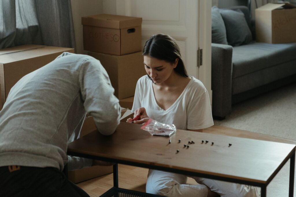 Couple assembling flat-pack furniture at home
