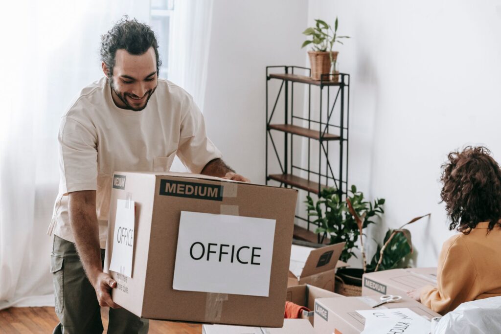 Man carrying a cardboard box labelled office
