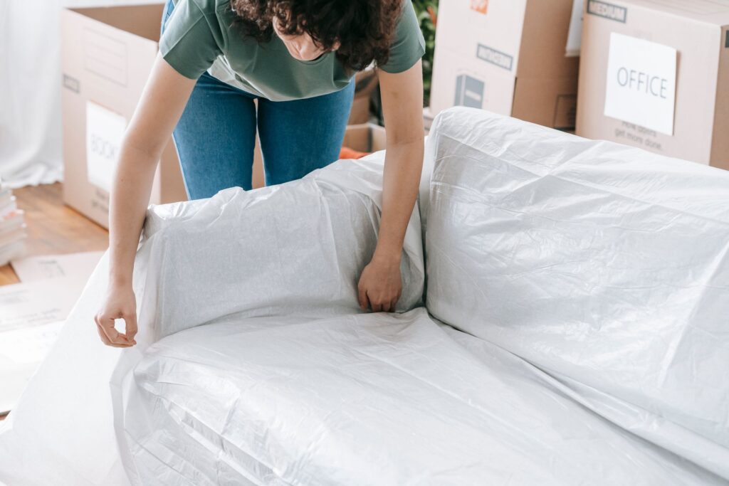 Couch being wrapped in protective plastic before a move